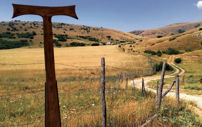 Paesaggio abruzzese con grande croce marrone lungo il cammino di san francesco